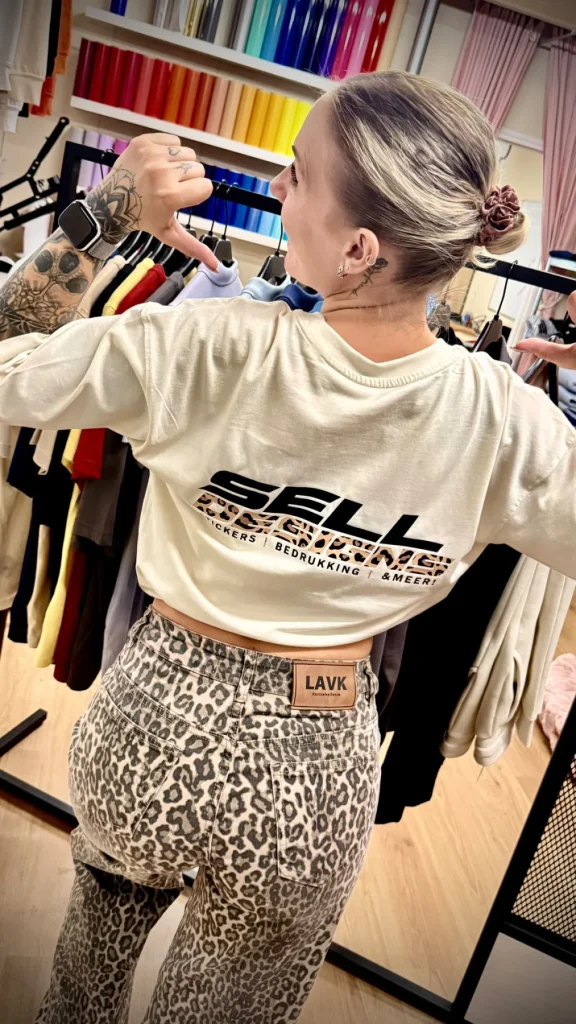 Grote Sell Designs-rugbedrukking op een licht T-shirt